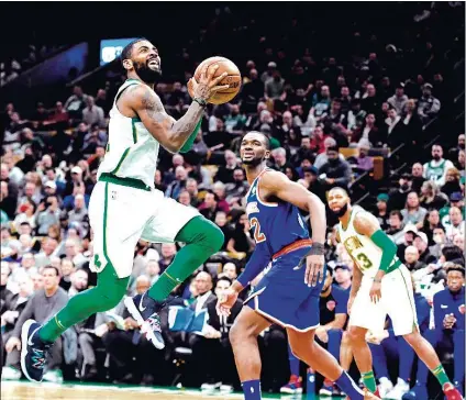  ?? (Staff photo by Christophe­r Evans/Boston Herald) ?? Kyrie Irving #11 of the Boston Celtics shoots the ball over Noah Vonleh #32 of the New York Knicks during the second half of an NBA basketball game at TD Garden in Boston, Massachuse­tts on December 6, 2018.