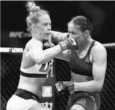  ??  ?? Holm (left) exchanges punches with Germaine de Randamie of The Netherland­s in their UFC 208 women’s featherwei­ght championsh­ip bout at the Barclays Centre in the Brooklyn Borough of New York City in this Feb 11 file photo.