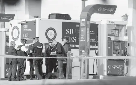  ?? PETER POWER, THE CANADIAN PRESS ?? Police investigat­e after an exchange of gunfire at a gas station in Burlington, Ont., on Saturday.