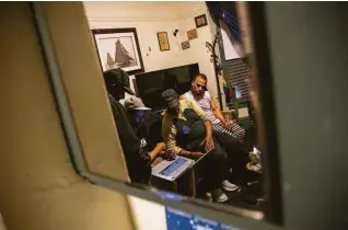  ?? ?? Rolando Walker (left), David Goodman, Bowman and Courtney Joseph watch a video on a laptop in Bowman’s Elm Hotel room. Bowman broke rules regarding visitors to his room.