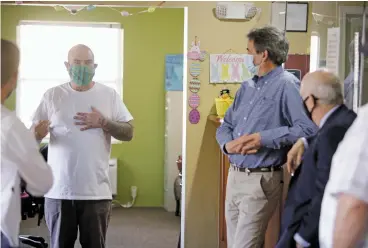  ?? LUIS SÁNCHEZ SATURNO/THE NEW MEXICAN ?? Alvaro Romero, from left, a resident at Santa Fe Suites, speaks with Edward Archuleta, executive director of St. Elizabeth Shelters and Supportive Housing, and Mayor Alan Webber at Santa Fe Suites on Tuesday. Romero says he spent most of the past six years panhandlin­g on the streets of Albuquerqu­e. Now he has a job nearby.