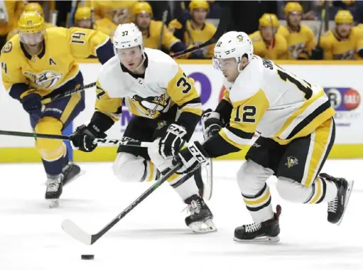  ?? Associated Press ?? Penguins center Dominik Simon (12) moves the puck down the ice with center Sam Lafferty (37) ahead of Nashville Predators defenseman Mattias Ekholm (14) Friday in Nashville, Tenn.