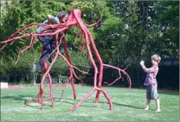  ?? GAO ERQIANG / CHINA DAILY ?? American artist Steve Tobin poses with an artwork from his SteelRoots series as his 8-year-old son, Milo, takes a photo.