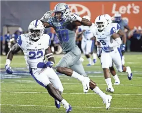  ?? MARK WEBER, THE COMMERCIAL APPEAL ?? University of Memphis receiver Damonte Coxie (middle) runs by the Georgia State University defense for a first down during action in Memphis, Tenn., Friday, September 14, 2018.