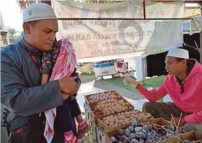  ??  ?? PENULIS tidak melepaskan peluang membeli pelbagai jenis kurma yang dijual di ladang.