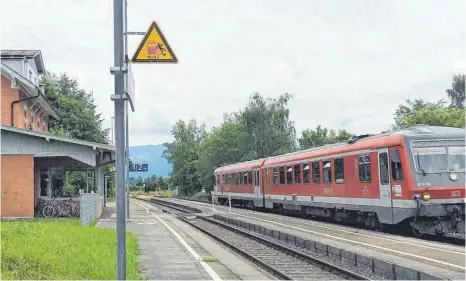  ?? FOTO: EVI ECK-GEDLER ?? Die Kette zu Gleis zwei ist zu, die Regionalba­hn fährt durch: Ein verlässlic­her Stundentak­t im Zugverkehr ist im Bahnhof Enzisweile­r noch nicht in Sicht.