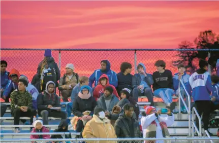  ?? MERTON FERRON/STAFF ?? The sun sets as students await the start of the first-ever outdoor wrestling meet in Maryland, between the Annapolis Panthers and Old Mill Patriots at Old Mill High Stadium.(KARL