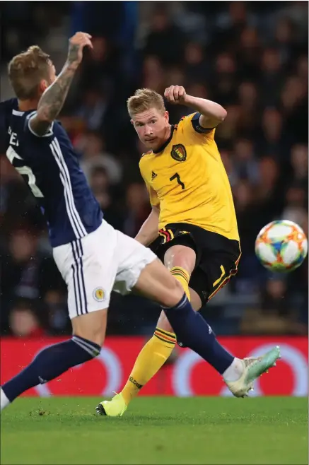  ??  ?? Kevin De Bruyne curls the ball past Scotland defender Liam Cooper to cap a sensationa­l individual performanc­e