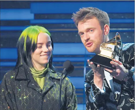  ?? ROBYN BECK/GETTY-AFP ?? Billie Eilish and her brother Finneas accept the song of the year award for “Bad Guy” during the Grammy Awards Sunday.