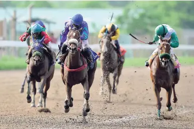  ??  ?? STIR IT UP (centre), with Javaniel Patterson aboard, winning the seventh race over 1600 metres at Caymanas park last Saturday.