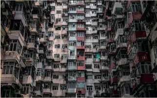  ?? ?? AIR conditioni­ng units on an apartment building in Hong Kong. A record-breaking heatwave is broiling parts of Asia, helping drive surging demand for cooling options, including air-conditioni­ng. AC exhaust units are a common feature of urban landscapes in many parts of Asia, clinging like limpets to towering apartment blocks in Hong Kong or tucked in a cross formation between the windows of a building in Cambodia. | DALE DE LA REY / AFP