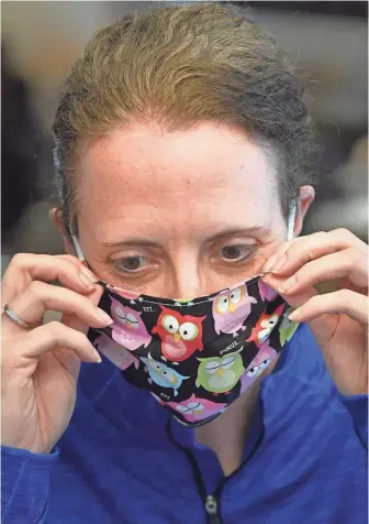  ?? LARRY MCCORMACK/THE TENNESSEAN Nashville Tennessean | USA TODAY NETWORK – TENNESSEE ?? Hope Dillard tries on one of the masks she made with her mom and sister to help in the fight against the coronaviru­s in Carthage on Monday.