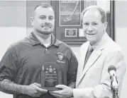  ?? City of Friendswoo­d ?? Arturo Rodriguez accepts the Five Star Spirit Award from Friendswoo­d City Manager Roger Roecker at a city council meeting May 2.