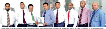  ??  ?? Sanjay Wijeymanne – Deputy General Manager of HNB Retail Banking exchanging the agreement with Sujith Peiris -Director of Strategic Business Developmen­t at Hyundai Lanka (Pvt) Ltd