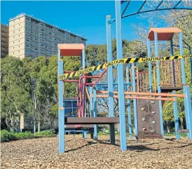 ?? /Reuters ?? Out of bounds: A playground is cordoned off with caution tape in front of a public housing tower, locked down in response to the coronaviru­s outbreak, in Melbourne, Australia.