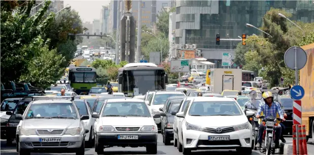  ?? AFP ?? Iranian drivers stop at a junction on a main street in the capital Tehran as the biting US sanctions returned on Tuesday. —