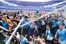  ?? MARTIN RICKETT PA VIA ASSOCIATED PRESS ?? Manchester City fans invade the pitch after their side won the English Premier League following a 3-2 victory over Aston Villa at The Etihad Stadium, Manchester, England on Sunday.