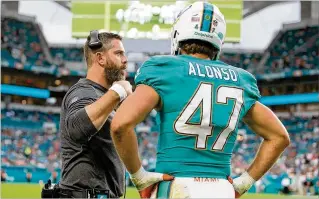  ?? ALLEN EYESTONE / THE PALM BEACH POST ?? Defensive coordinato­r Matt Burke (talking with linebacker Kiko Alonso during a preseason game) employs a technique from mentor Jim Schwartz to keep his players’ attention.