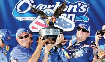  ?? — AFP ?? LONG POND: Kyle Busch, driver of the #18 M&amp;M’s Caramel Toyota, poses with the trophy in victory lane after winning during the Monster Energy NASCAR Cup Series Overton’s 400 at Pocono Raceway on Sunday in Long Pond, Pennsylvan­ia.