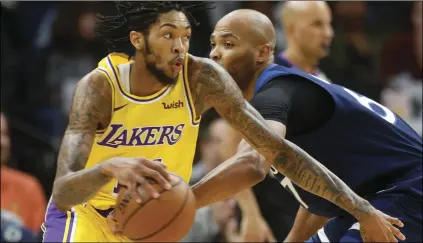  ?? AP PHOTO/JIM MONE ?? Los Angeles Lakers’ Brandon Ingram, left, drives around Minnesota Timberwolv­es’ Taj Gibson as Gibson reaches for the ball in the first half of an NBA basketball game on Monday, in Minneapoli­s.