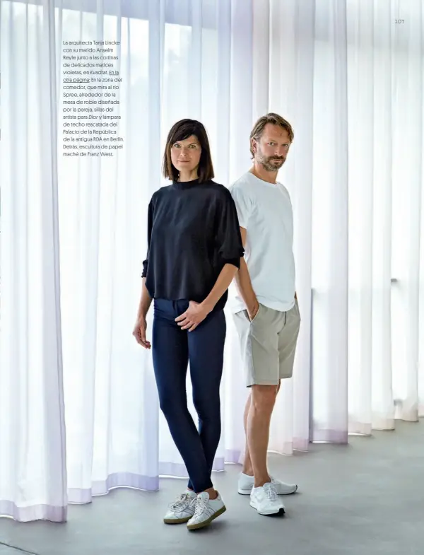  ??  ?? La arquitecta Tanja Lincke con su marido Anselm Reyle junto a las cortinas de delicados matices violetas, en Kvadrat. En la otra página: En la zona del comedor, que mira al río Spree, alrededor de la mesa de roble diseñada por la pareja, sillas del artista para Dior y lámpara de techo rescatada del Palacio de la República de la antigua RDA en Berlín. Detrás, escultura de papel maché de Franz West.