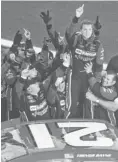  ?? MARK J. REBILAS, USA TODAY SPORTS ?? Trevor Bayne, second from right, celebrates with his team after winning the Daytona 500 in February 2011.