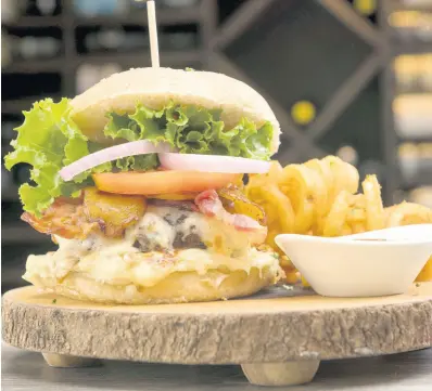  ?? PHOTOS BY GLADSTONE TAYLOR ?? The mouthwater­ing barbecue bacon burger is handmade with 100 per cent beef.