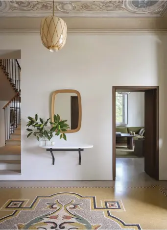  ??  ?? This page
Original flooring and mosaic tiles were retained, and natural materials in the form of a 1920s Carl Westman lantern and vintage Danish oak-framed mirror complement the yellow tones. The wall-mounted marble shelf, custom designed by Studio Daminato, adds a contempora­ry touch
Facing page
The details of the Liberty-style ceiling are the focal point in this sitting room, where Studio Daminato’s furniture designs (with the exception of Maxalto armchairs), inspired by the muted and minimal work of Giorgio Morandi, are subtle enough not to detract from the details overhead. The rounded form of a Japanese paper and timber lantern mirrors the circular motif of the ceiling pattern