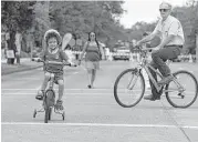  ?? James Nielsen / Houston Chronicle ?? Four-year-old Chauncy Rowe-Watters got to ride his bike during the Cigna Sunday Streets event in the Museum District before more rain hit the area.