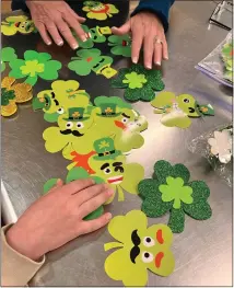  ?? JENNIFER MEYERS — COURTESY PHOTO ?? Michelle Grady and 8-year-old Oliver Meyers look through his shamrock crafts he made for Meals on Wheels. Jennifer Meyers, Oliver’s mom, said the second grader made around 150 of the crafts.