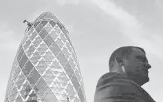  ??  ?? A City worker is silhouette­d in front of the‘Gherkin’ building in the City of London. Britain’s banking and insurance regulator has warned motor and home insurers about the risks of drawing on the reserves they have built up against future claims to...