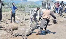  ?? NITIN KANOTRA/HT ?? Locals retrieve the carcass of a goat killed in storm in Rajouri, on Wednesday.