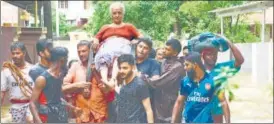  ?? PTI ?? An elderly woman being rescued from flood waters, triggered by heavy rains in Palakkad.