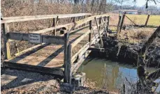  ?? FOTO: STADT AULENDORF ?? Marode und gesperrt: Der Holzfußgän­gersteg führt zu einem Schreberga­rten und muss erneuert werden.