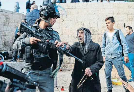  ?? AHMAD GHARABLI / AFP ?? Una soldado israelí en la puerta de Damasco que da acceso a la Ciudad Vieja, en la zona palestina de Jerusalén, ayer por la mañana