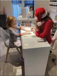  ?? WILLIAM TILTON — THE NEWS-HERALD ?? Daphney Wohlgemuth of Wickliffe gets her nails painted as part of the Styles With Santa event at Eden Off the Avenue in Mentor on Nov. 26.