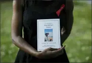  ?? MATT DUNHAM — THE ASSOCIATED PRESS ?? Local resident Marcia Mullings poses for photograph­s with an order of service from the funeral of her older brother Gary Mullings, aged 53, who recently died of cancer, which she brought with her to a remembranc­e event where Gary’s name was added to the community “We Grieve” wall at Clapton Common May 28 in London.