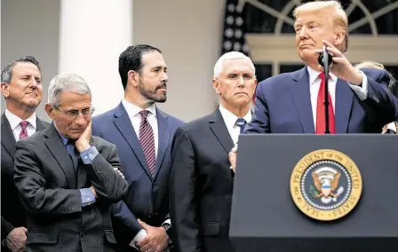  ?? Evan Vucci / AP ?? El presidente Donald Trump (der.), rodeado de asesores, habla de la emergencia nacional por el coronaviru­s en una conferenci­a de prensa en el rosedal de la Casa Blanca, en Washington D.C., el viernes 13 de marzo.