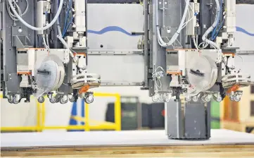  ??  ?? A machine cuts holes into drywall in the wall sheathing area of the Blueprint Robotics facility in Baltimore on April 10.