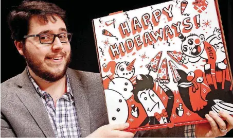  ?? [PHOTOS BY DOUG HOKE, THE OKLAHOMAN] ?? Sam Washburn, an Edmond artist, shows off his Happy Hideaways illustrati­on for Hideaway’s large pizza boxes. The restaurant will serve up its large pies to go in the boxes beginning Nov. 20, a spokesman said.