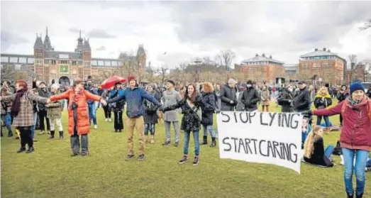  ?? ROB ENGELAAR / EFE ?? CONTRA EL TOQUE DE QUEDA EN HOLANDA. La Policía neerlandes­a dispersó ayer dos protestas contra el toque de queda decretado el sábado, en el centro de Amsterdam (en la imagen) y en Eindhoven, utilizando cañones de agua, caballos, perros, porras y gases lacrimógen­os. Fue el colofón a la primera noche con el confinamie­nto nocturno, que se saldó con 3.600 multas y 25 arrestos.