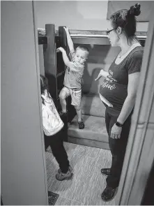  ??  ?? Four year-old Wade and his sister Shay, 5, explore an RV with their parents, Clint and Laura Hall. The family has been looking for an RV to fit their family of five with one more on the way.