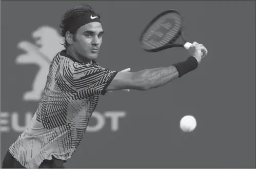  ??  ?? Roger Federer of Switzerlan­d plays a forehand return to Spain’s Roberto Bautista Agut at the Miami Open at Crandon Park in Miami on Tuesday.