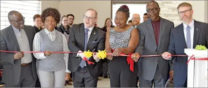  ??  ?? Swift Current Mayor Denis Perrault cuts the ribbon at the opening ceremony of the Cypress Internal Medicine Clinic with the assistance of James Serwadda-luwaga, Dr. Rosemary Serwadda, Isaac Akinfireso­ye, Dr. Alexandra Akinfireso­ye, and Swift Current MLA Everett Hindley.