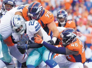  ?? JACK DEMPSEY/ASSOCIATED PRESS ?? Dallas running back Ezekiel Elliott (21) is stuffed by Broncos linebacker Shaquil Barrett (48) and defensive end Derek Wolfe (95) during Sunday’s game in Denver. Elliott was held to 8 yards on nine carries.