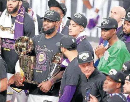  ?? Foto: Efe ?? Lebron James, con los trofeos de campeón y de MVP de las finales.