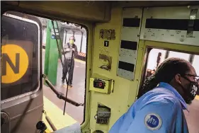  ?? JOHN MINCHILLO/ASSOCIATED PRESS ?? Desmond Hill, a vaccinated Metropolit­an Transporta­tion Authority conductor, looks out his crew cab window to check the platform for late-arriving passengers on the subway line from Brooklyn’s Coney Island to Queens on Aug. 13.