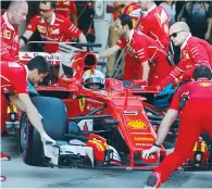  ??  ?? MECHANICS PUSH the car of Ferrari Formula One driver Sebastian Vettel of Germany at the Russian Grand Prix yesterday. Vettel went on to take Ferrari’s first pole position since 2015 and the 47th of his career.