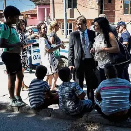  ?? — AFP ?? Teachers and social workers talk to children in the Roma neighbourh­ood of Stolipinov­o.