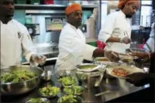  ?? AP PHOTO/STEVEN SENNE ?? In this Oct. 2, 2018 photo Phillip Oliver, of New Bedford, Mass., center, in recovery from opioid addiction, helps serve a meal in a culinary training program at the New England Center for Arts and Technology, in Boston.